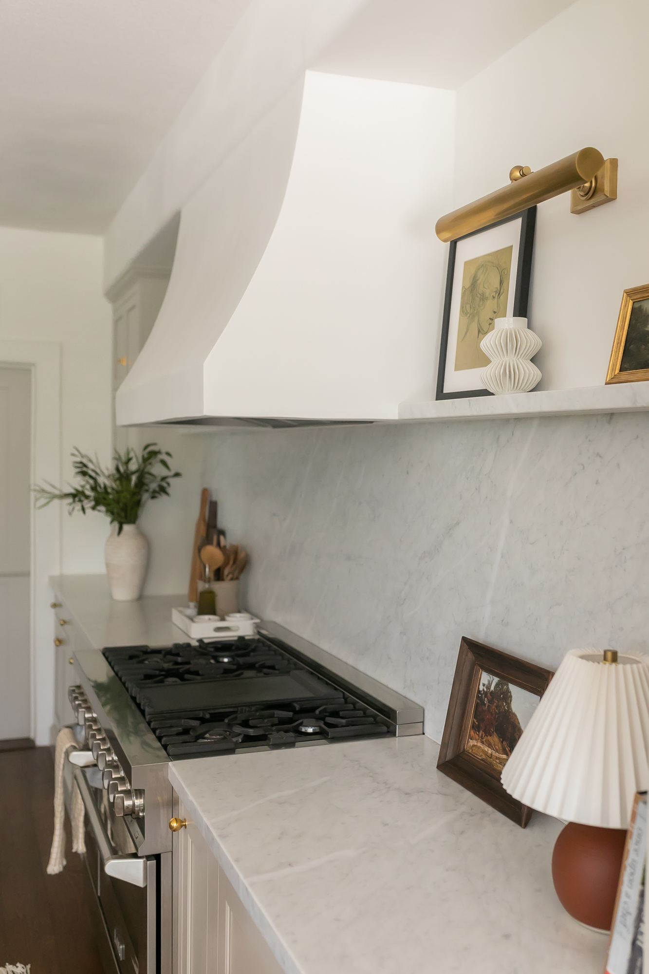 Kitchen range with marble backsplash, white plaster hood, and brass accessories — J. Arthur Custom Homes Texas Hill Country